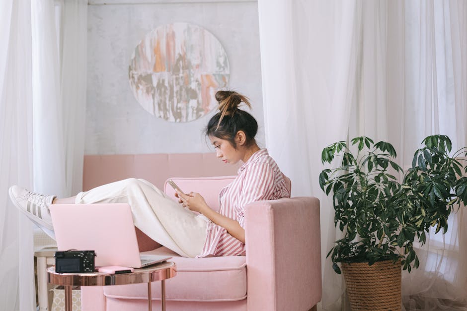 Asian woman in a cozy home interior, sitting and relaxing with technology, showcasing modern lifestyle.