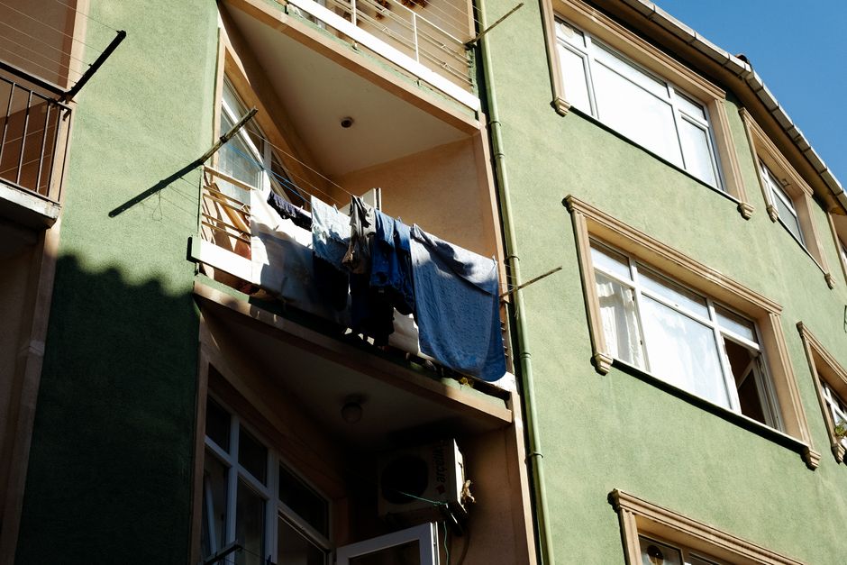 Laundry hanging on a sunny day from an apartment balcony.