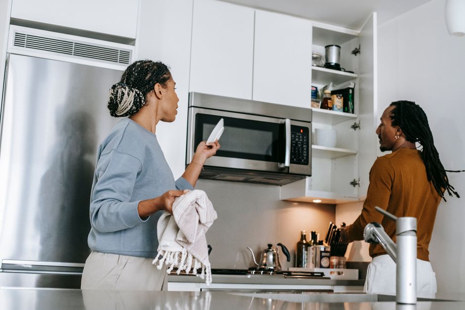 African American male and female standing and arguing in kitchen and wearing casual outfit in daytime